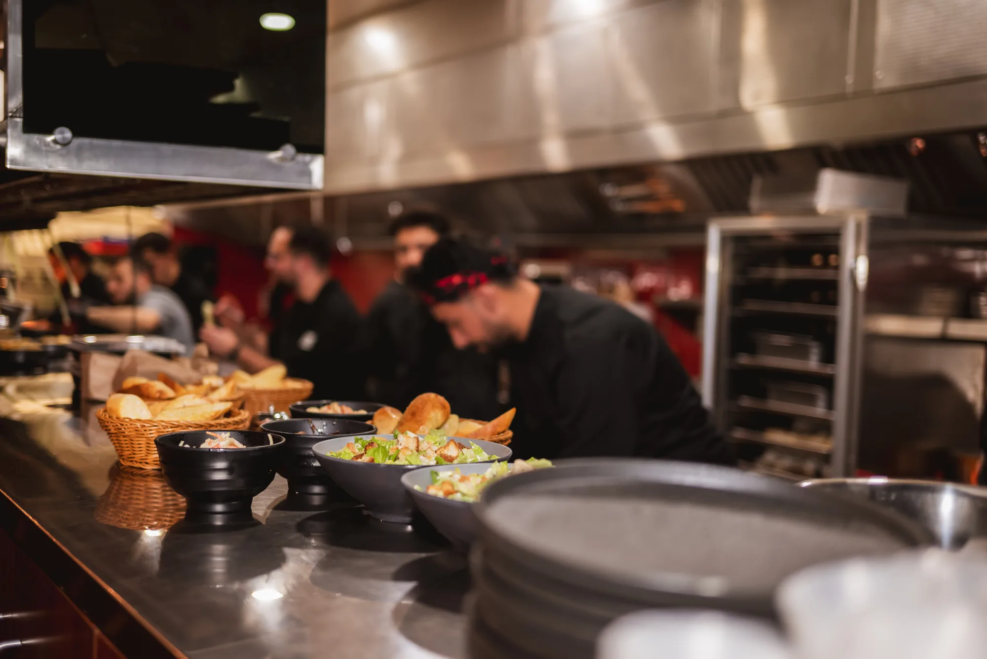 Chefs plating dishes on the open kitchen line at Backyard Smokehouse Edmonton