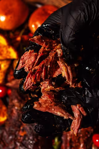 Chef holding tender pulled smoked meat at Backyard Smokehouse Toronto