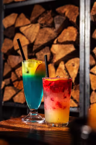 Signature layered cocktails by the woodpile at Backyard Smokehouse Toronto