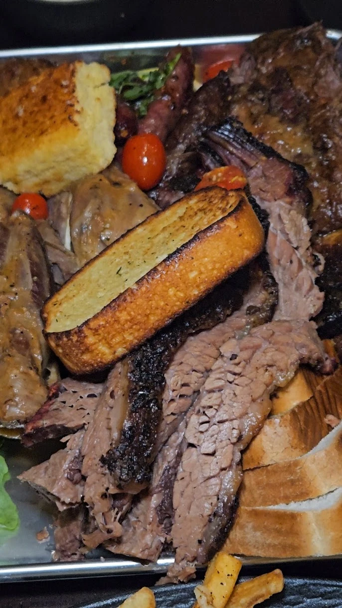 Signature BBQ platter featuring smoked meats, brisket, and golden cornbread.