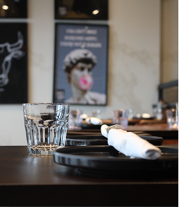 Table setting with glassware and plates in the Backyard Smokehouse Edmonton dining area.