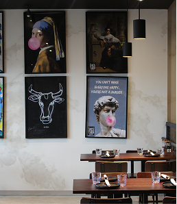 Modern interior of Backyard Smokehouse Edmonton featuring quirky wall art and seating.