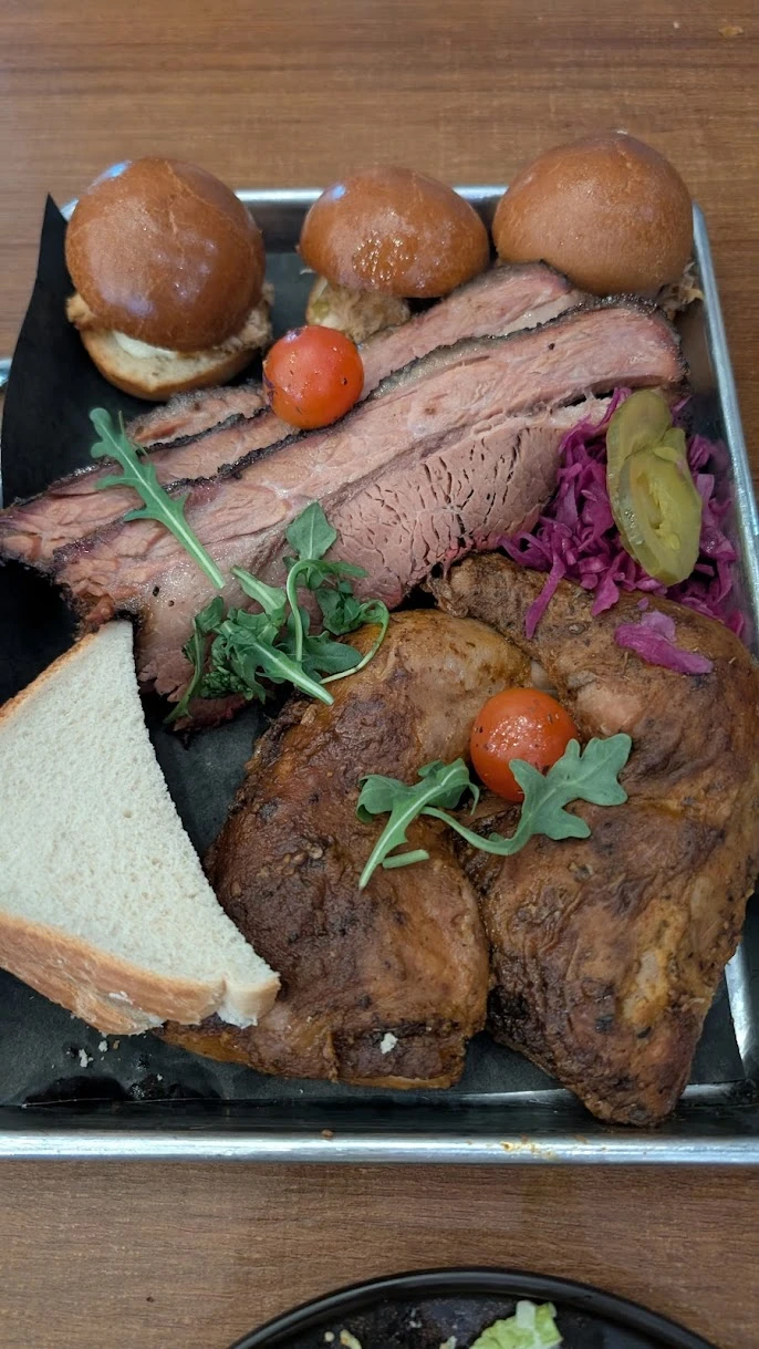 Juicy grilled steak served on a rustic wooden platter at Backyard Smokehouse.