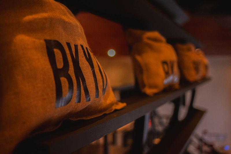 Backyard Smokehouse Edmonton BKYD branded burlap bags lined up on shelf in restaurant
